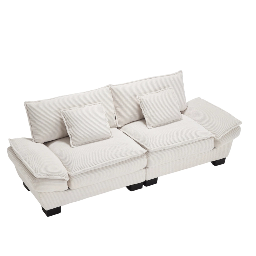 Divano imbottito in velluto beige con seduta profonda, cuscini e braccioli per il relax