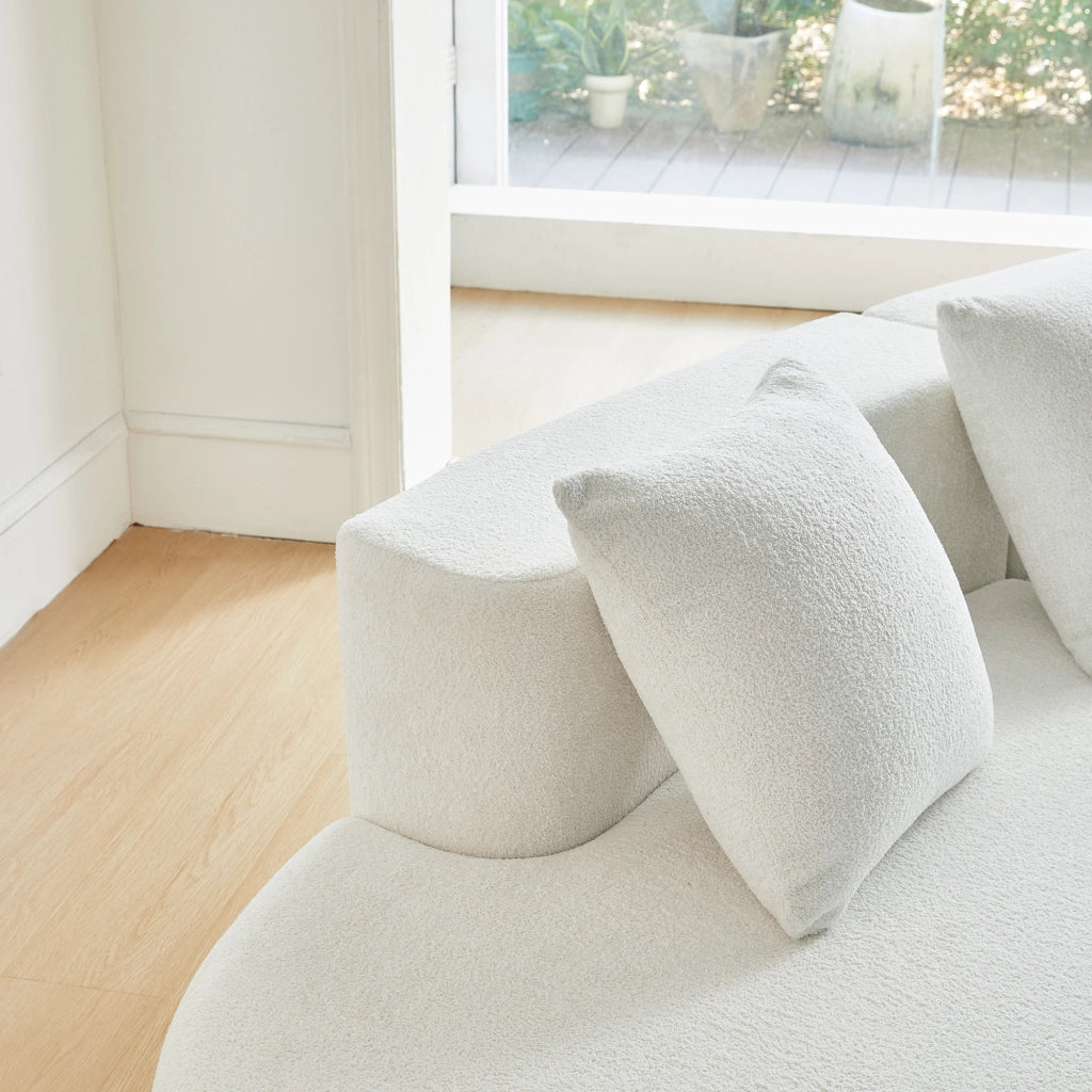 Divano ad angolo modulare a 3 posti con design curvo e cuscini decorativi, in tessuto bianco per soggiorno e appartamento
