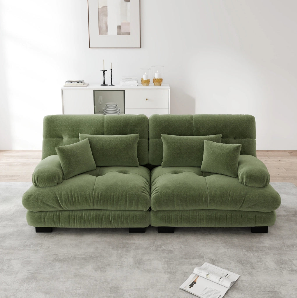 Divano modulare in ciniglia verde con braccioli arrotondati; cuscini lombari e decorativi