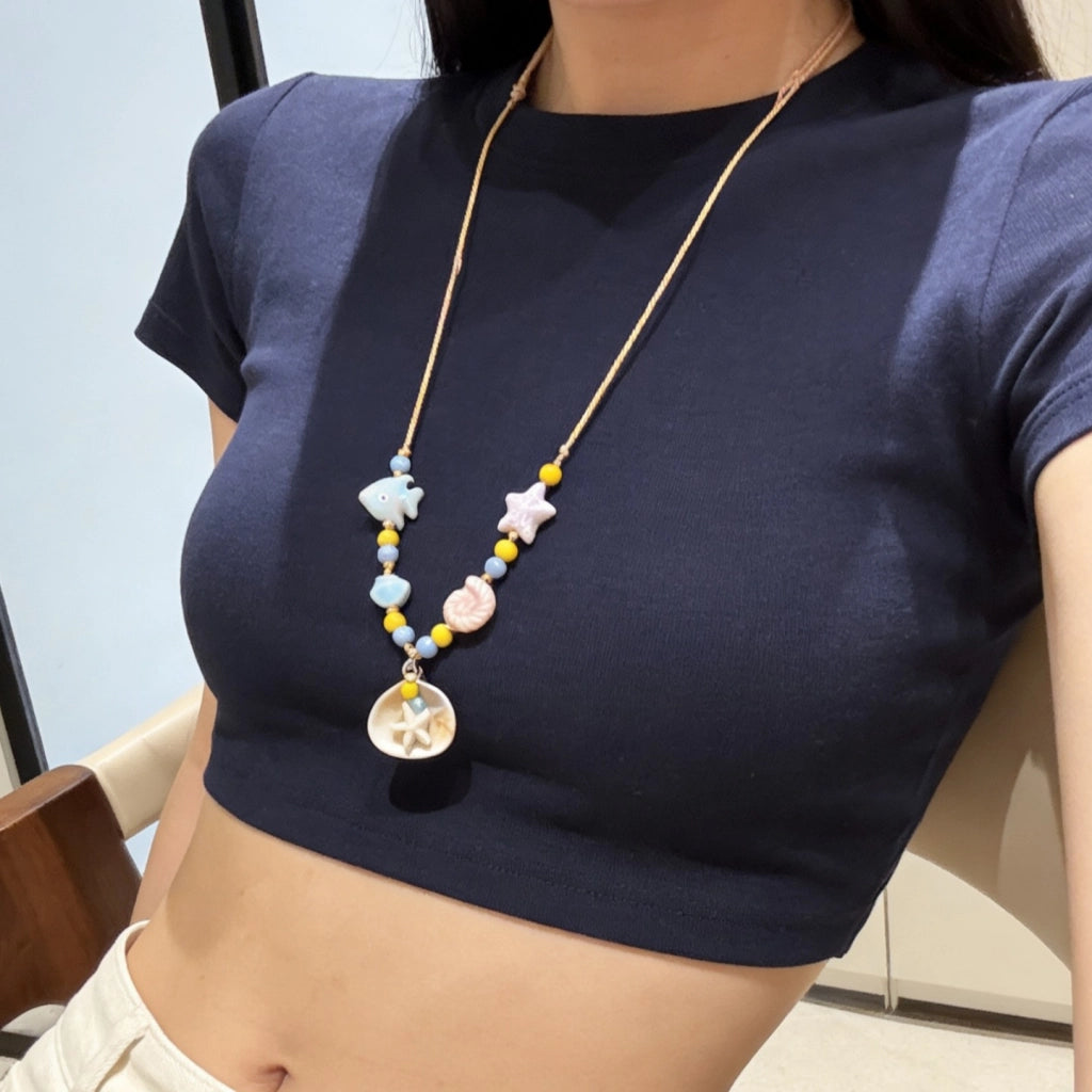 Collana con ciondolo a forma di stella marina e conchiglia, ricca di dopamina.