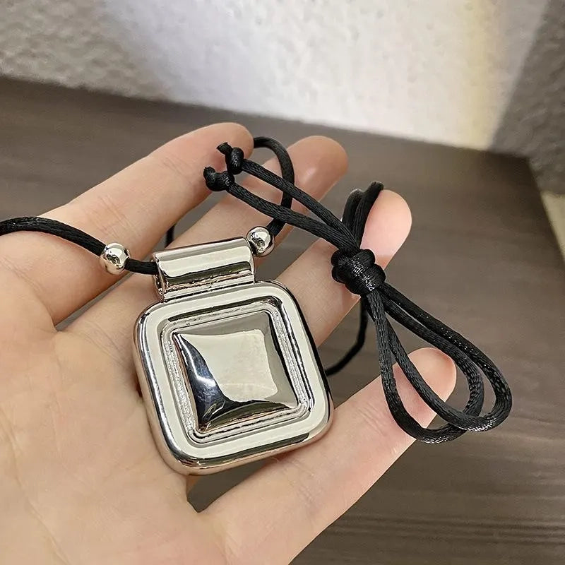 Collana con pendente quadrato in metallo nero, realizzata a mano: decorazione con perline.