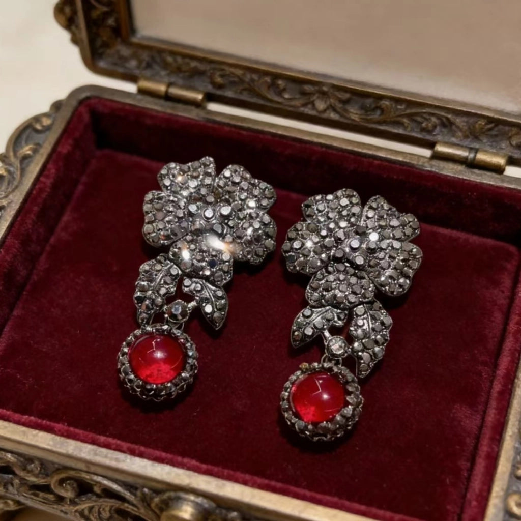 Orecchini a petalo retr¨°-chic, sofisticati e lussuosi, interamente tempestati di diamanti e con cristalli rossi.