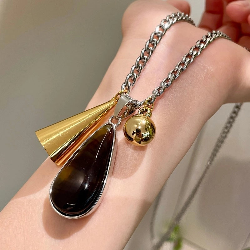 Collana vintage con pendente a goccia d'ambra e lunga catena marrone da donna.