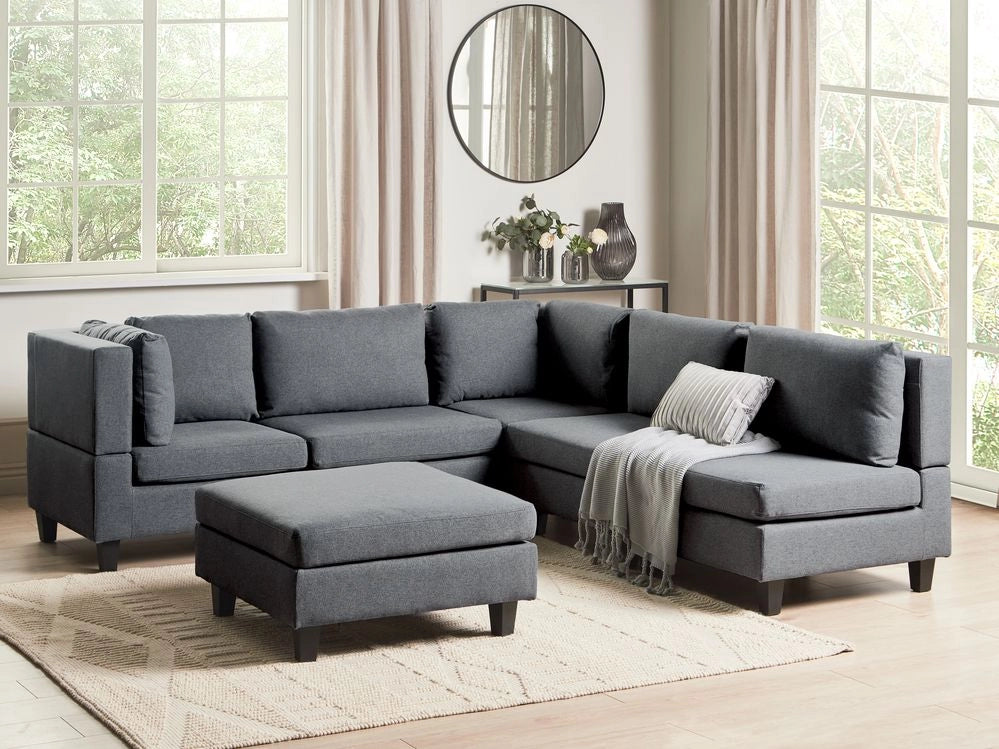 Divano componibile a 5 posti imbottito lato destro in tessuto grigio scuro con gambe nere e pouf stile moderno