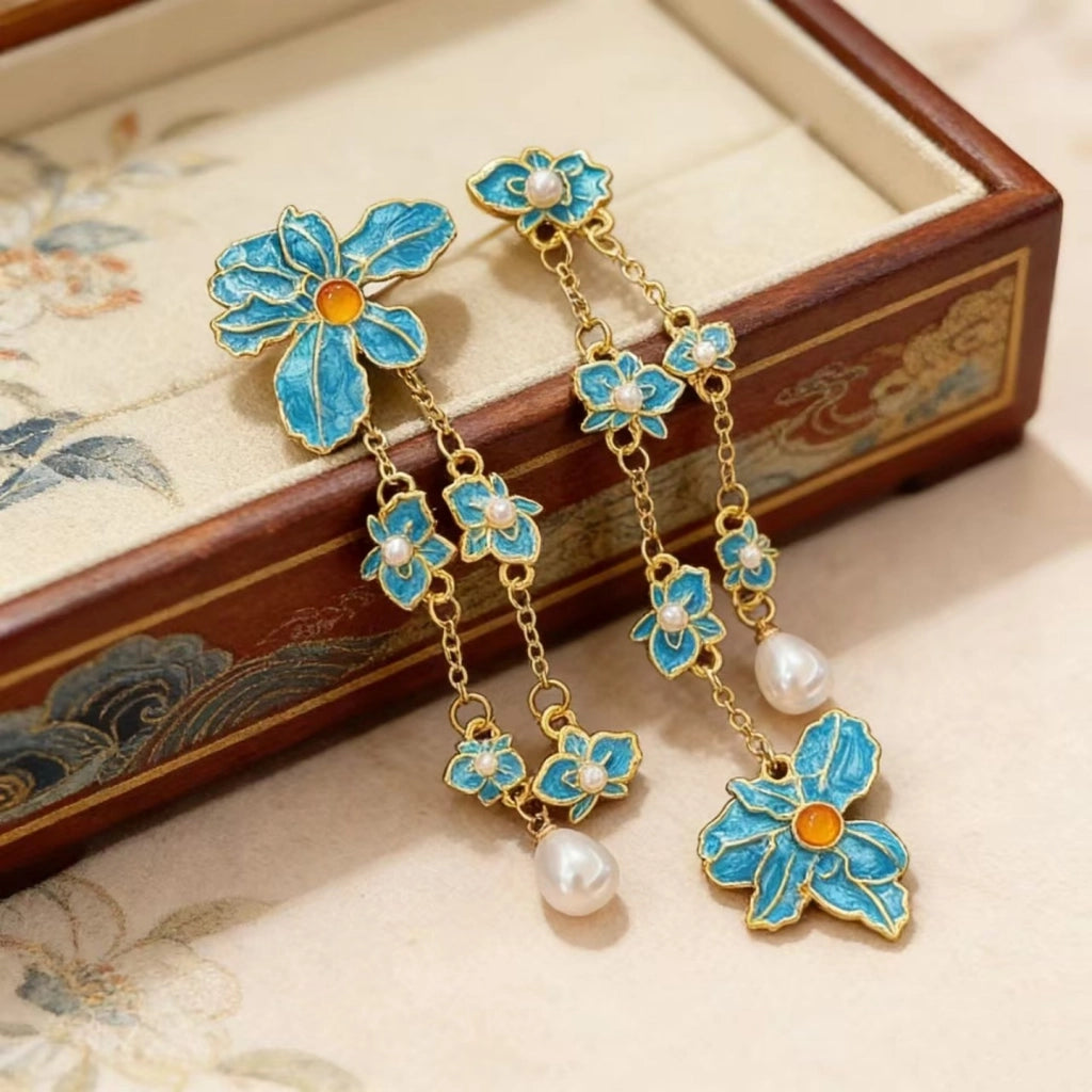 Orecchini pendenti con perle di cristallo a forma di petalo blu.