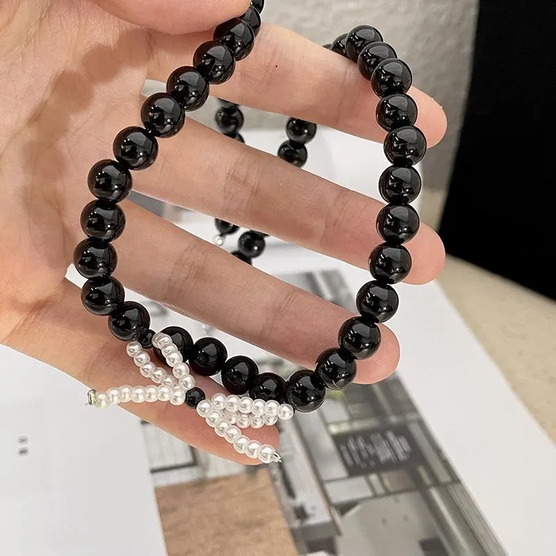 Collana con fiocco in corda nera e perline: regalo fatto a mano per donna.