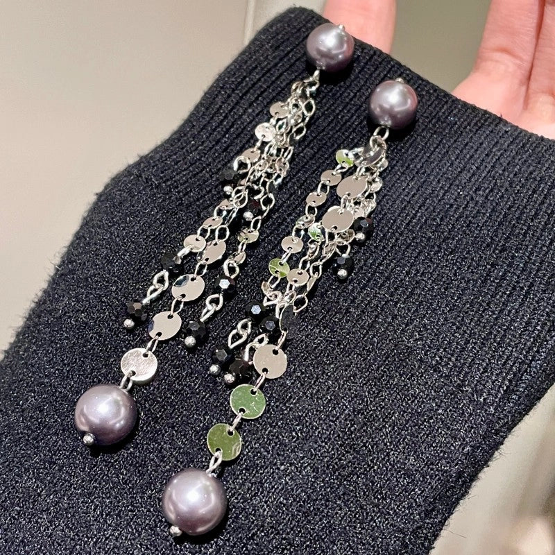 Orecchini pendenti con paillettes argentate scintillanti e orecchini a lobo con perle grigie e argentate luccicanti.