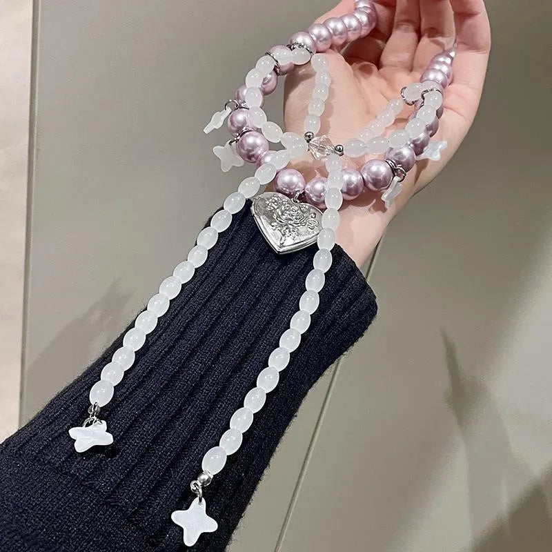 Collana con fiocco fatta a mano con perle rosa e viola.