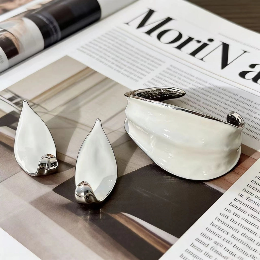 Bracciale e orecchini in smalto bianco a forma di voluta: gioielli di nicchia, minimalisti e di alta gamma per donna.