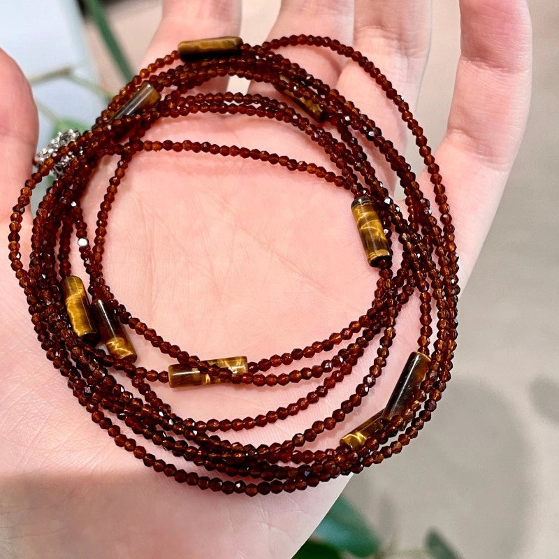 Collana girocollo lunga a pi¨´ strati con perline di cristallo marrone e pietra occhio di tigre, un accessorio di tendenza e alla moda.