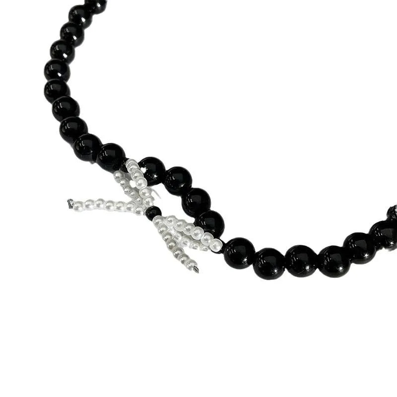 Collana con fiocco in corda nera e perline: regalo fatto a mano per donna.