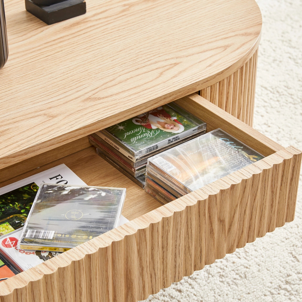 Tavolino basso ovale con cassetto e vano aperto frontali zigrinati in MDF effetto rovere chiaro per soggiorno 118 × 65 × 17 cm