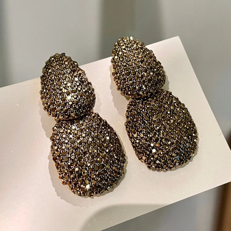 Design lussuoso e sofisticato, orecchini geometrici a forma di goccia con dettagli in diamanti.