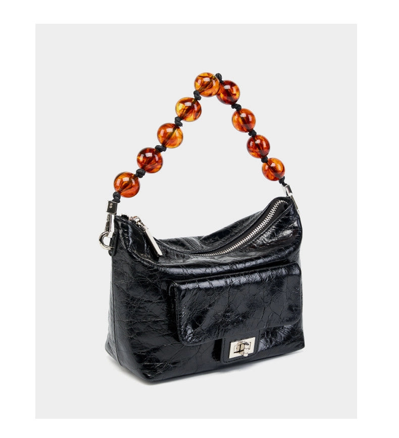 Borsa a mano plissettata in vera pelle vintage cerata, nera.
