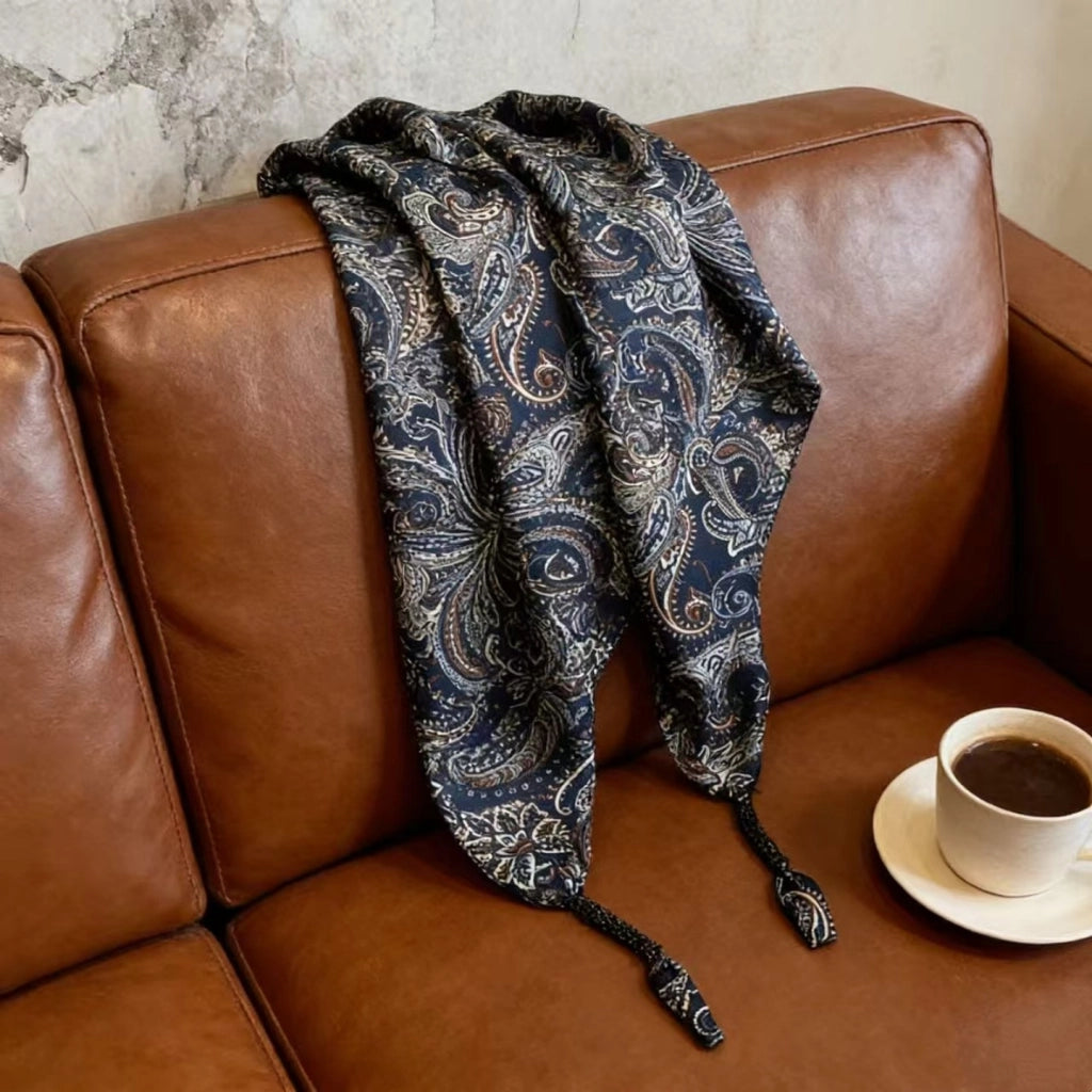 Cintura decorata con sciarpa paisley blu scuro abbinata a pantaloni, jeans e gonna, sovrapposta a una sciarpa triangolare e a una patta posteriore.