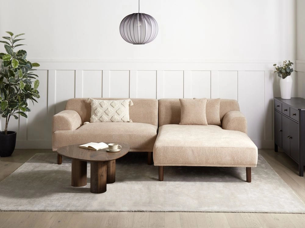 Divano ad angolo sinistro in tessuto beige lato sinistro e gambe in legno stile minimalista