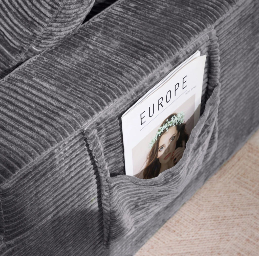 Divano compatto in velluto a coste grigio scuro con tasche laterali e cuscini per il relax