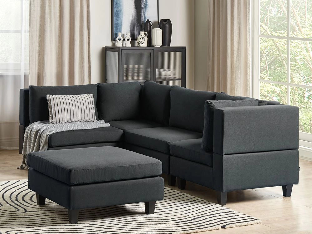 Divano componibile 4 posti imbottito in tessuto nero con gambe nere schienale imbottito lato destro con pouf stile moderno