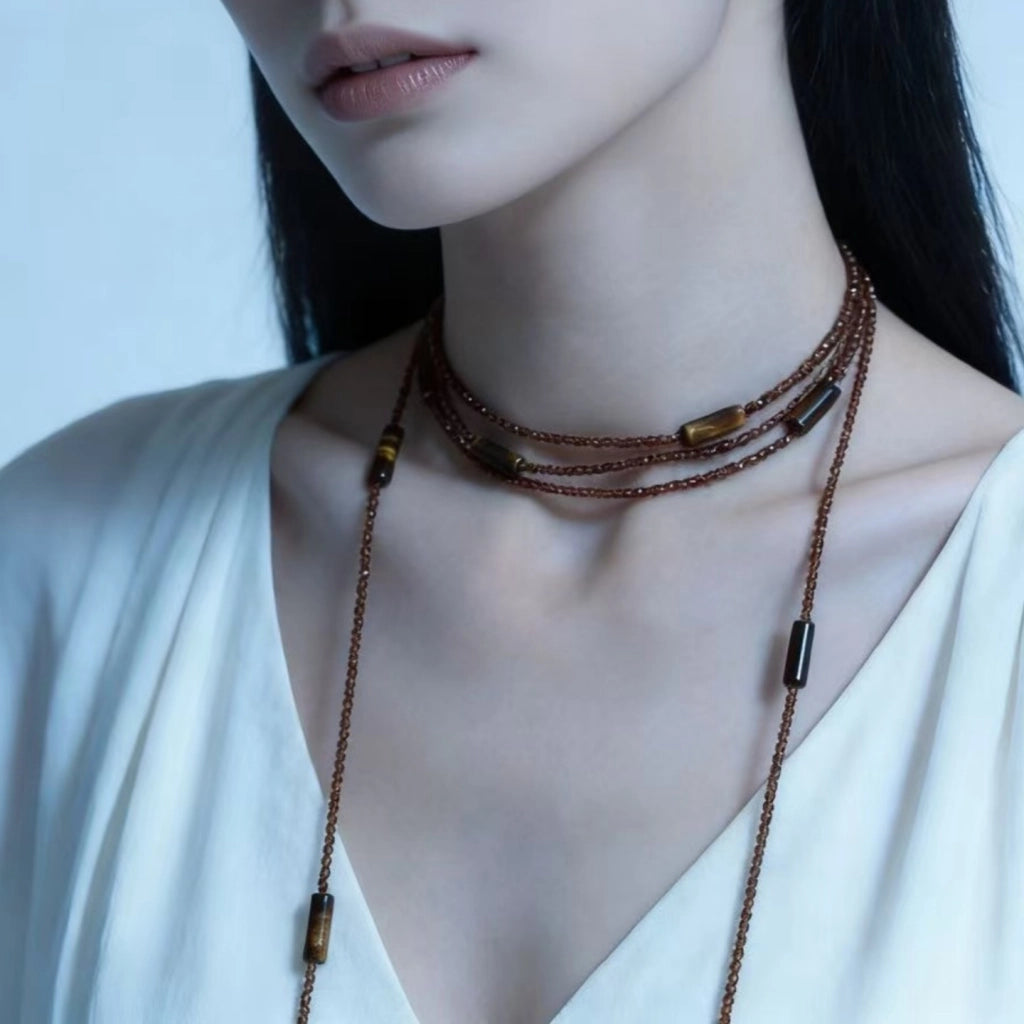 Collana girocollo lunga a pi¨´ strati con perline di cristallo marrone e pietra occhio di tigre, un accessorio di tendenza e alla moda.
