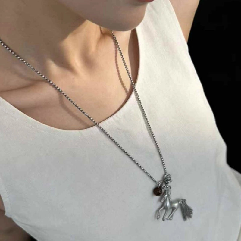 Collana lunga vintage con ciondolo a forma di pony e catena in metallo.