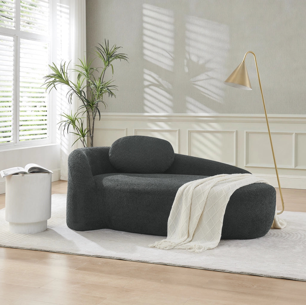 Divano minimalista in Teddy nero; morbido con cuscino testa; design arrotondato