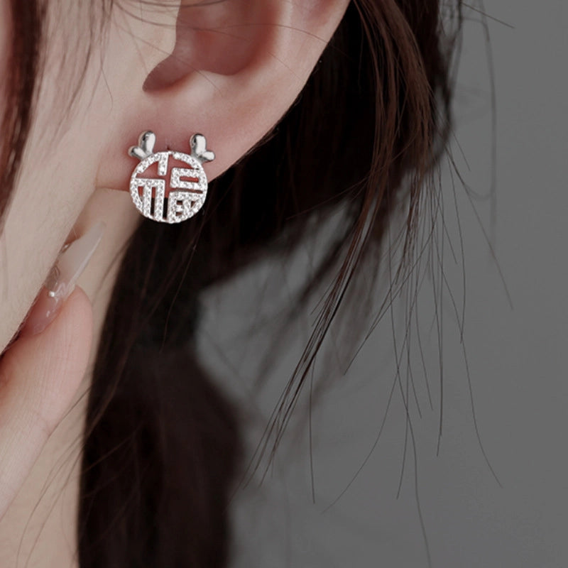 Orecchini a spillo in argento sterling S925 con cuore in zirconi microincastonati e disegno traforato del carattere "Fu".