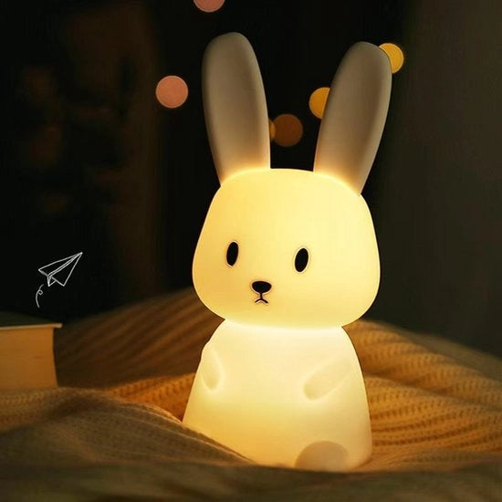 Lampada per bambini in forma di coniglio con 7 livelli di illuminazione, ricaricabile via USB, superficie battente in silicone, 1200 mAh, destinata all'uso accanto al letto nella camera da letto.