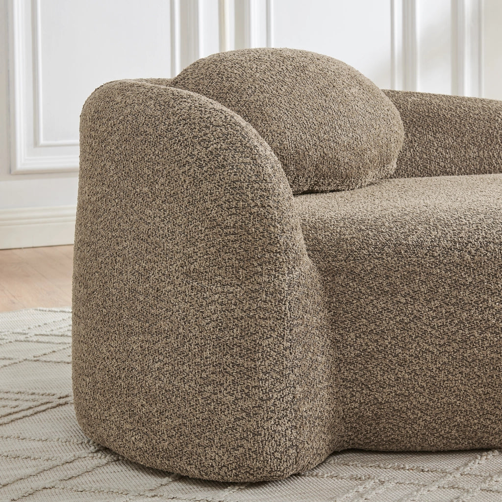 Divano minimalista in tessuto Teddy marrone con design arrotondato e cuscino di supporto