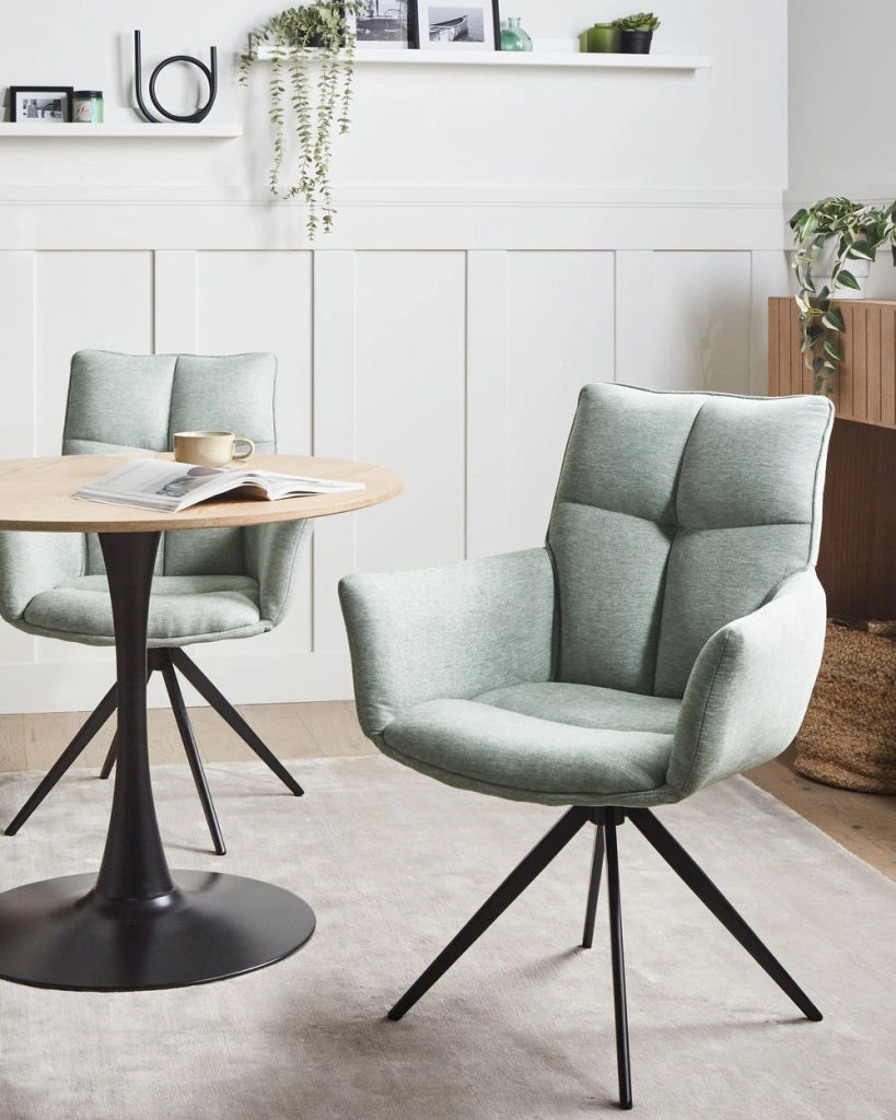 Sedia da pranzo Mint con rivestimento in poliestere, gambe in ferro nero, braccioli e base girevole stile moderno per la sala da pranzo.