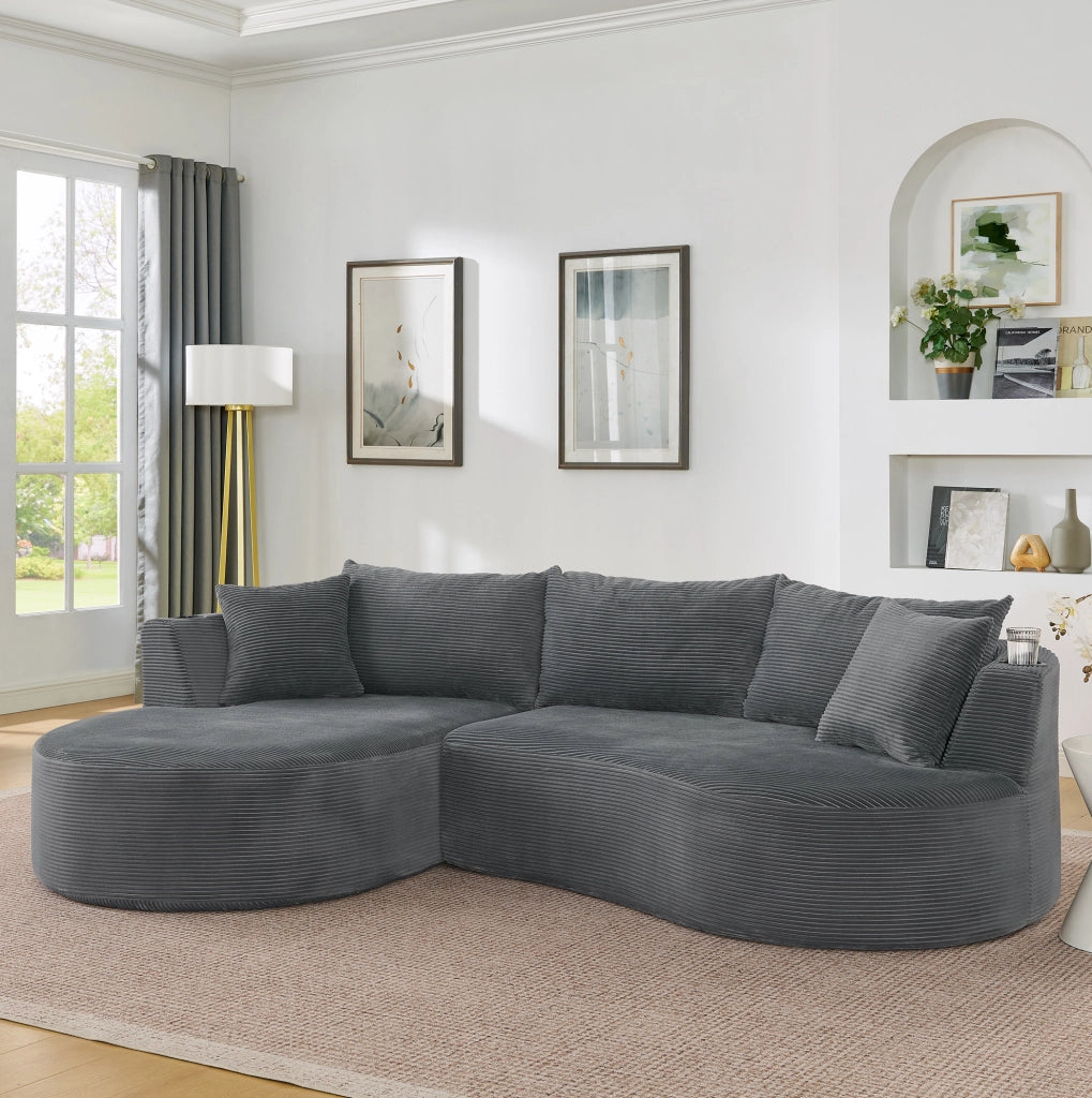 Divano a 3 posti dal design curvo in tessuto corduroy grigio; con portabicchieri e cuscini