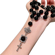 Collana a catena a tre strati con perline di cristallo nero e ciondolo a croce, ideale da portare lungo la clavicola.