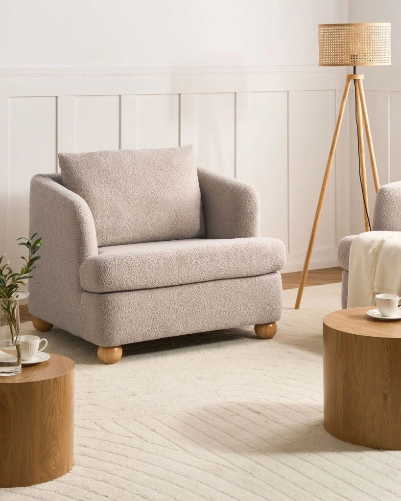 Poltrona beige in bouclé con rivestimento, gambe rotonde in legno e braccioli, soggiorno, angolo lettura stile moderno minimalista