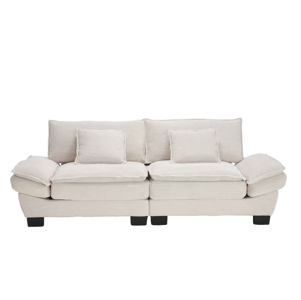 Divano imbottito in velluto beige con seduta profonda, cuscini e braccioli per il relax