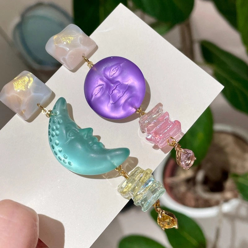 Orecchini dal design unico e sofisticato, che raffigurano le fasi lunari e solari: orecchini a lobo asimmetrici in argento con un tocco di viola.