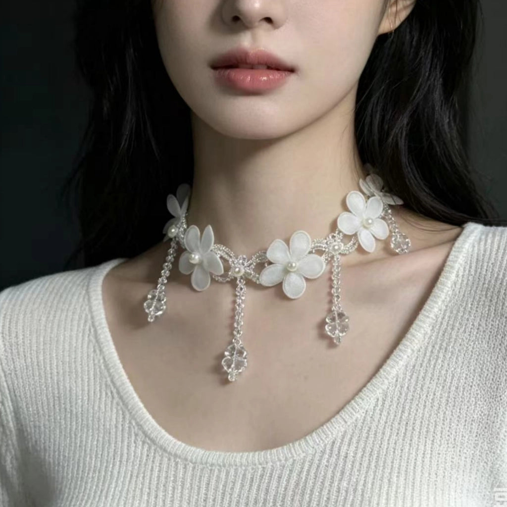 Collana fatta a mano con fiore in pizzo bianco, perle e nappe di cristallo.