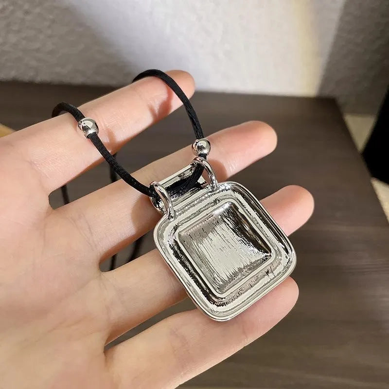 Collana con pendente quadrato in metallo nero, realizzata a mano: decorazione con perline.