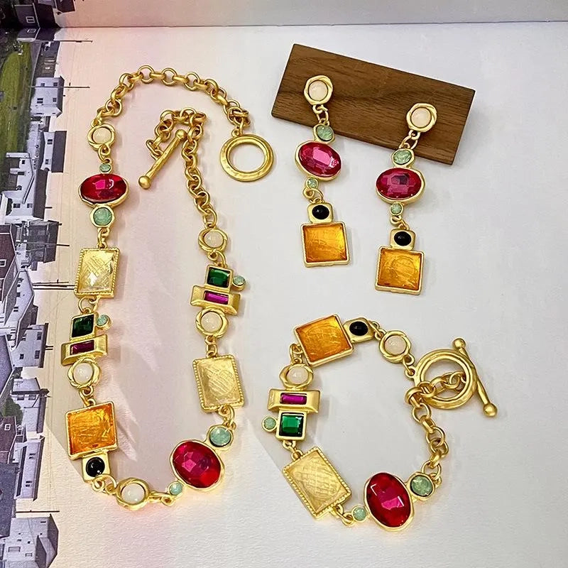 Set di collana, bracciale e orecchini realizzati a mano con pietre preziose artificiali colorate.