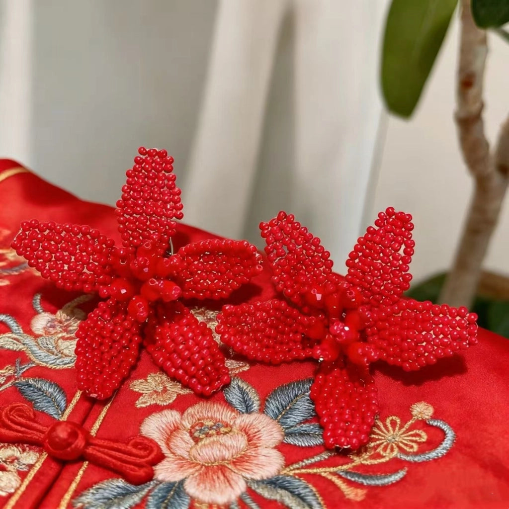 Orecchini a forma di fiore con perline rosse intrecciate a mano