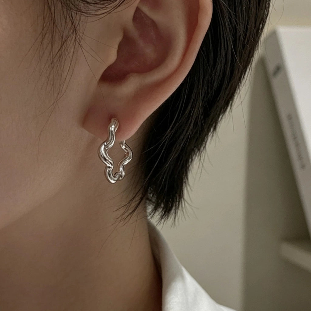 Orecchini a forma di fiore ondulato, minimalisti e dalle linee fredde.