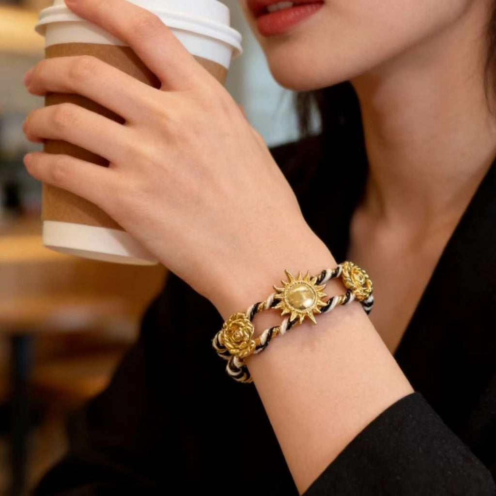 Bracciale regolabile da donna con girasoli in metallo traforato e intrecciato a mano.