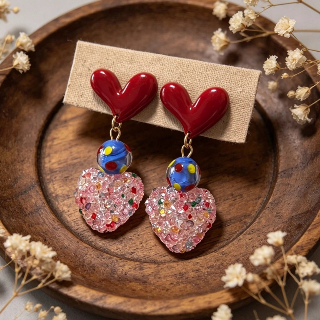 Orecchini rossi a forma di cuore con zucchero dopaminergico e cuore rosa tridimensionale.