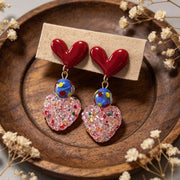 Orecchini rossi a forma di cuore con zucchero dopaminergico e cuore rosa tridimensionale.