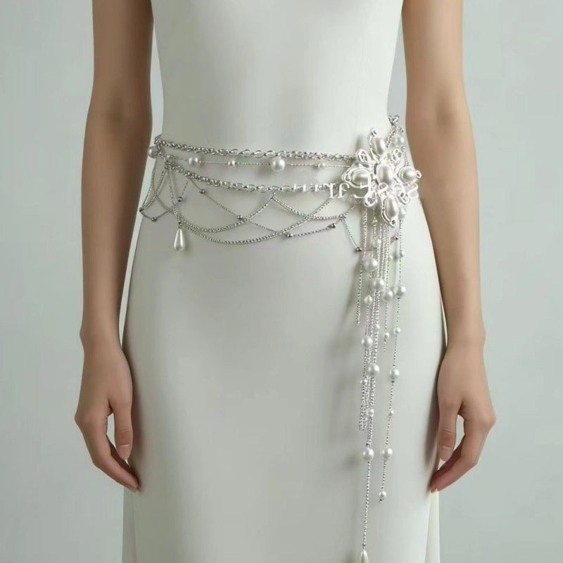 Cintura da donna con catena a croce e fiore di perla e nappe di perline.
