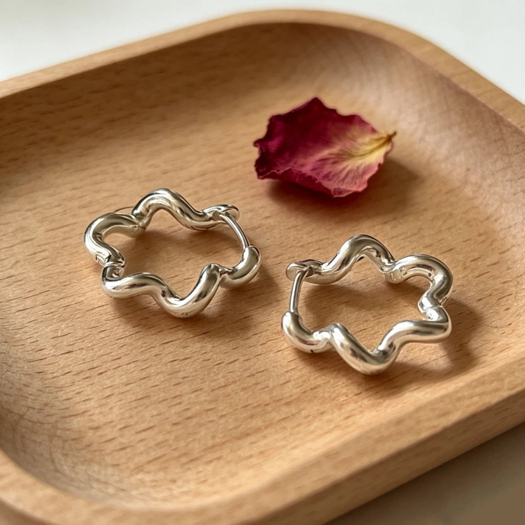 Orecchini a forma di fiore ondulato, minimalisti e dalle linee fredde.
