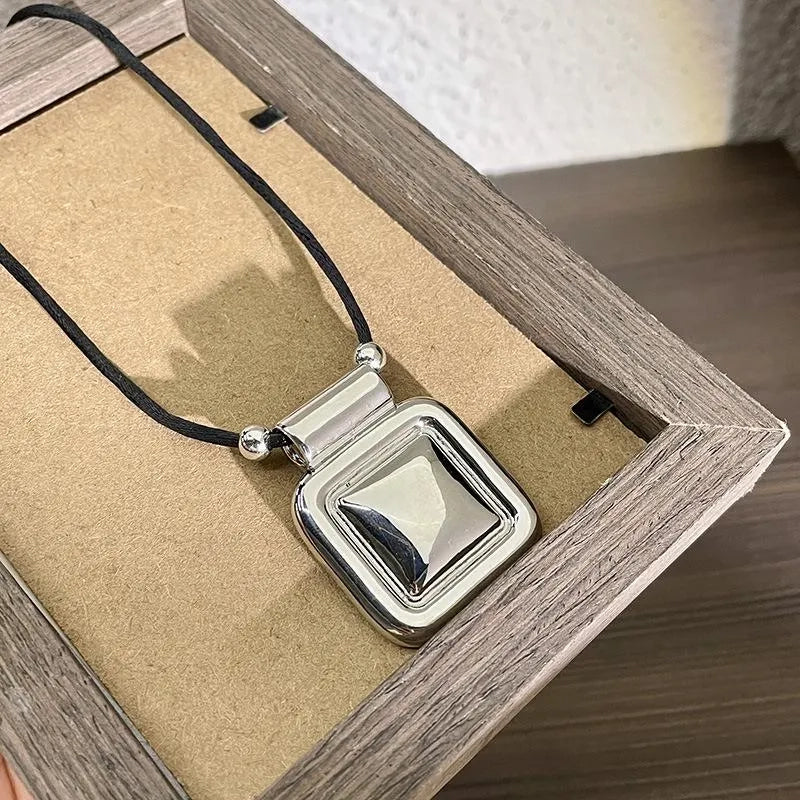 Collana con pendente quadrato in metallo nero, realizzata a mano: decorazione con perline.
