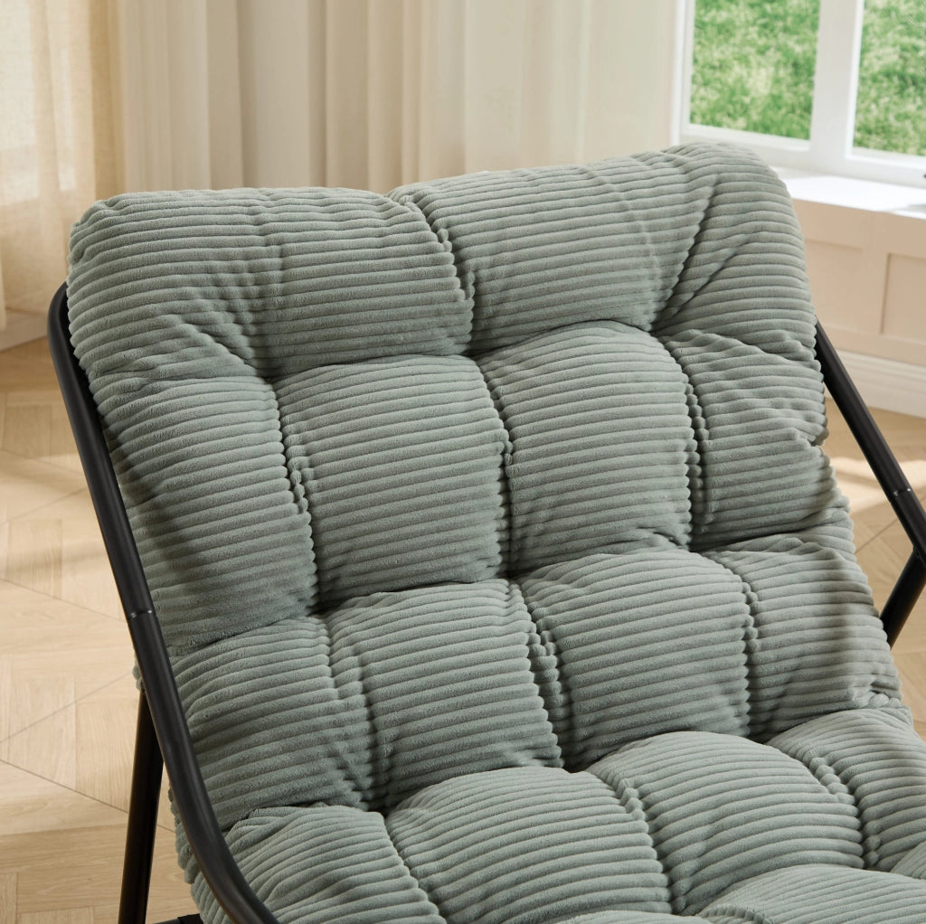 Poltrona a dondolo con pouf, struttura nera e cuscino verde chiaro
