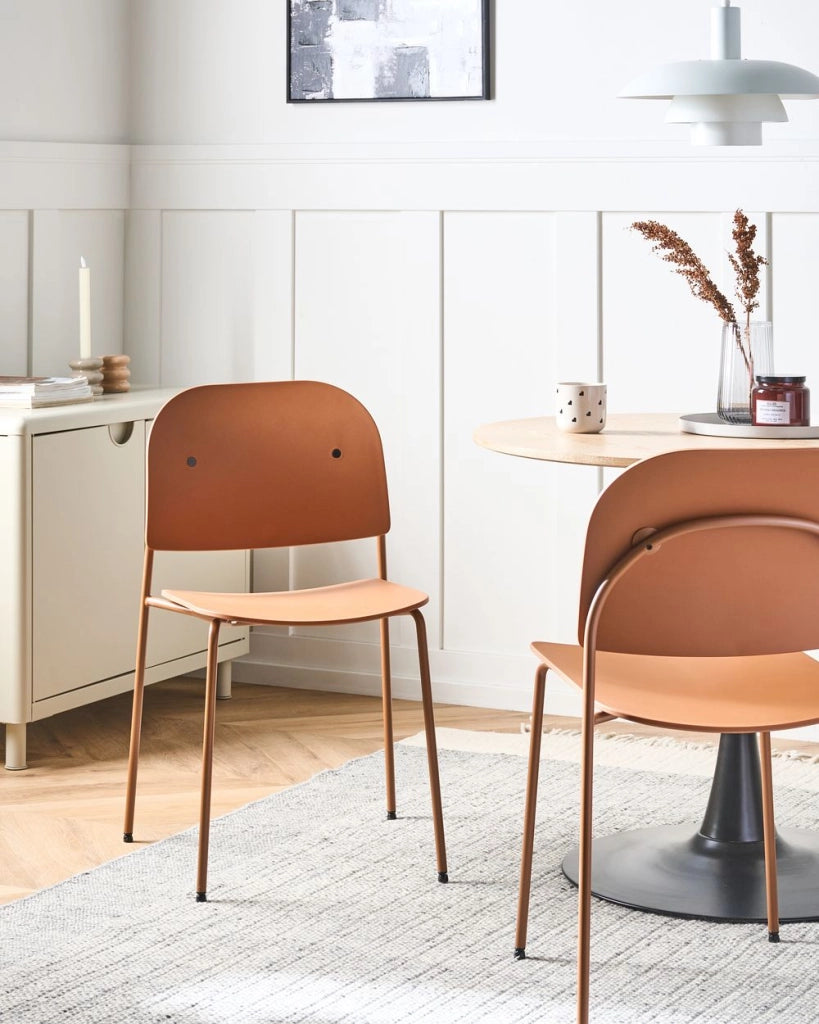 Set di 2 sedie da pranzo con seduta in materiale sintetico arancione e struttura in metallo, in stile minimalista scandinavo, per la zona pranzo della cucina