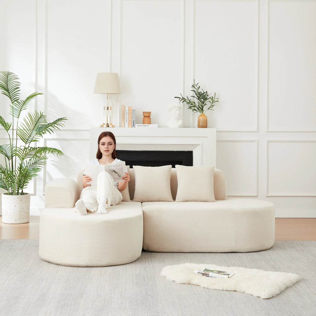 Divano angolare a L con chaise longue; braccioli curvi e cuscini in velluto a coste beige