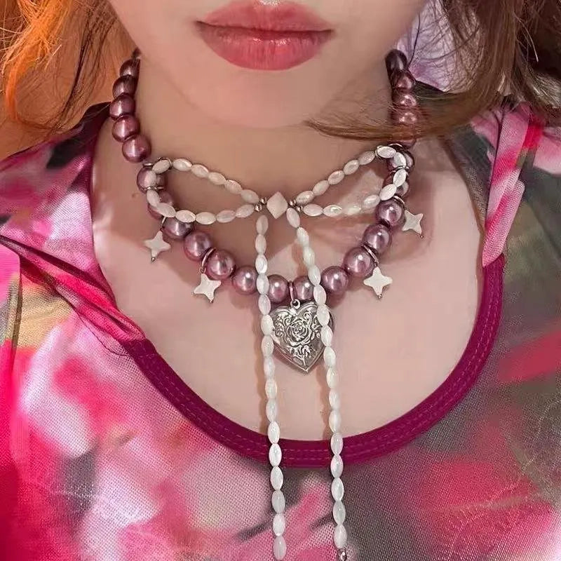 Collana con fiocco fatta a mano con perle rosa e viola.