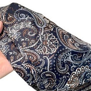 Cintura decorata con sciarpa paisley blu scuro abbinata a pantaloni, jeans e gonna, sovrapposta a una sciarpa triangolare e a una patta posteriore.